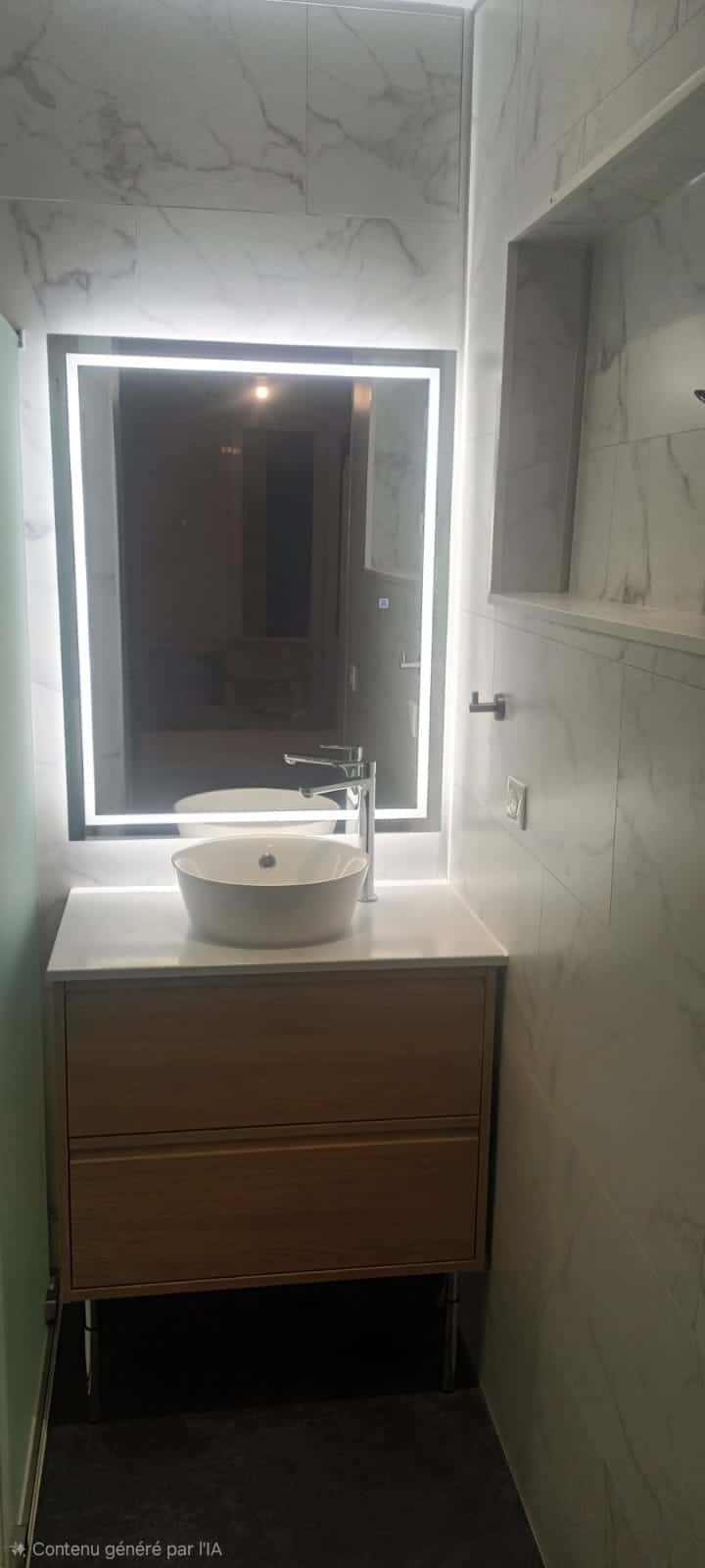 Meuble de salle de bain en bois avec vasque blanche et grand miroir LED sur fond de carrelage effet marbre blanc.